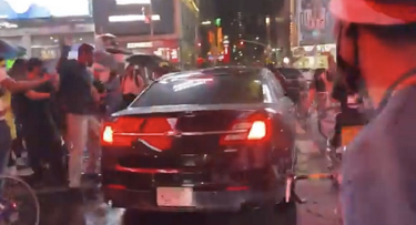 タイムズ・スクエアで抗議者たちの中を危険走行する車